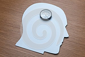 A compass is centered on a white, head-shaped cutout.