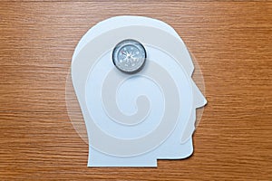 A compass is centered on a white, head-shaped cutout.