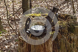 Compass in the forest on a stump in the sunlight