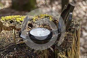 Compass in the forest on a stump in the sunlight