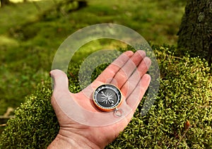 Compass in hand at forest. Tourist compass for orientation on the terrain. Magnetic declination Ñalculator. Historical explorer