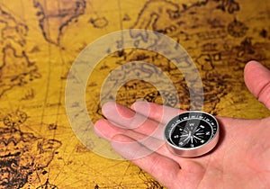 Compass in hand on map. Tourist compass for orientation on the terrain. Magnetic declination Ñalculator. Historical explorer help