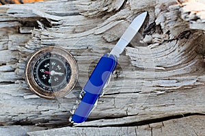 Compass and a knife for survival on an old dried tree.