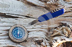 Compass and a knife for survival on an old dried tree.