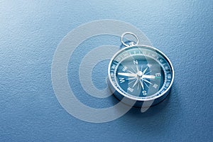 Compass lying on a blue office desk. Concept for business and creativity