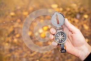 Compass is manâ€™s hand in forest for searching for right direction