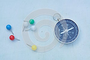 Compass and marking pins on white canvas background