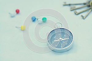 Compass and marking pins on white canvas background