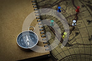 Compass and notebook on blur vintage world map, journey concept, copy space