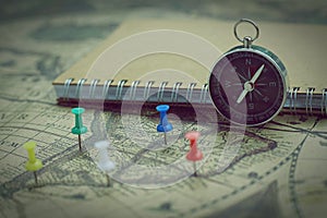 Compass and notebook on blur vintage world map, journey concept, copy space