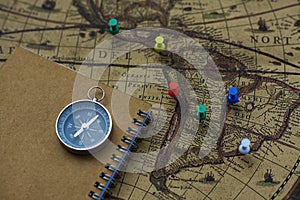 Compass and notebook on blur vintage world map, journey concept, copy space