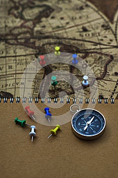 Compass and notebook on blur vintage world map, journey concept, copy space