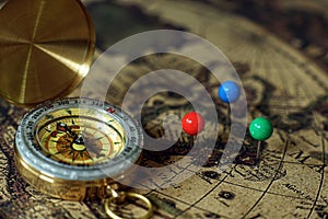 Compass and notebook on vintage world map, journey concept, copy space photo