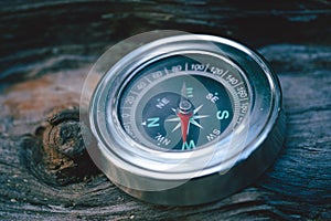 Compass on old wood background. Vintage style and selective focus.