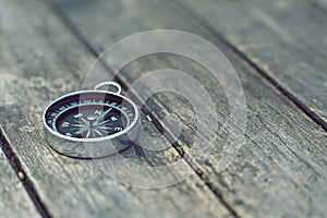 Compass on old wooden table background, journey concept, vintage tone