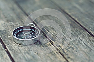 Compass on old wooden table background, journey concept, vintage tone photo