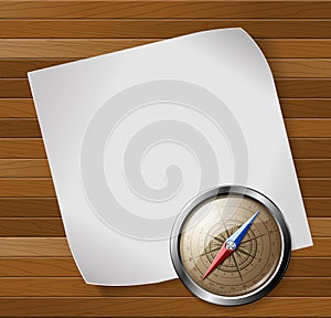 Compass and paper sheet over wooden background.