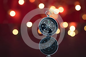 Compass with red background and bokeh of decoration light on par