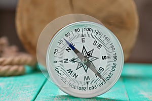 Compass and rope on wooden texture background