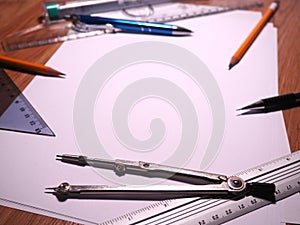 Compass, ruler, pencil and sheet of paper on the table