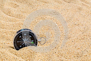 Compass in the sea sand on beach background with copy space for add text message or use components for design. Summer Travel