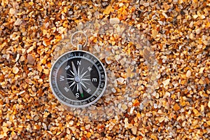 compass on sea sand and place for text. close up of navigation device on sandy beach without people, top view