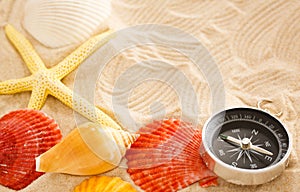 Compass, seastar and seashells in sand