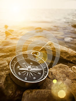 Compass on the shore at sunrise