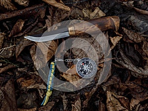 Compass and survival knife on fallen leaves. Tools for Hiking and survival