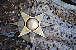 Compass windrose medallion with polar coordinates on wet metal decorated background