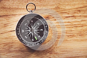 Compass on wooden background with space for text