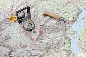 Compass and wooden-handled knife on a hiking map