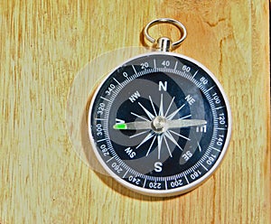 Compass on the wooden table pointing west