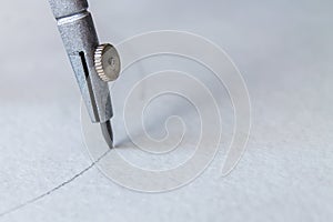 Compasses draw a circle on a sheet of paper