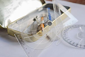 Compasses, pencil and rulers on squared paper photo