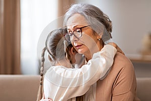 Compassionate Grandmother Embracing Her Young Granddaughter in Warm Indoor Setting