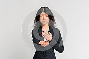 Compassionate teen girl ask for help, reaching hands of hand to the camera, standing in black blazer over grey background. Human