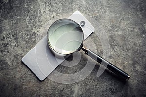 Scrutinizing Costs A Magnifying Glass Focuses on a Blank Price Tag Against a Grungy Background Highlighting the photo