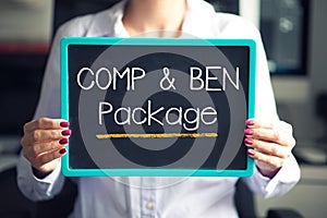 Compensation and benefits at job concept with comp and ben text written on cardboard hold by employee
