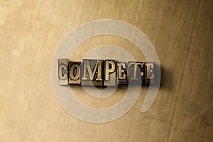 COMPETE - close-up of grungy vintage typeset word on metal backdrop