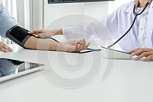 Competent attentive doctor being measuring blood pressure to pat