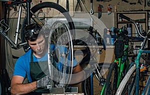 Competent bicycle mechanic in a workshop repairs a bike.