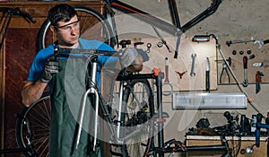 Competent bicycle mechanic in a workshop repairs a bike.