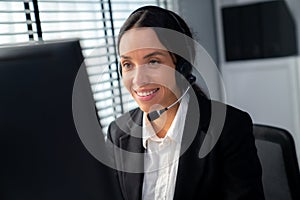 Competent female operator working on computer and while talking with clients.