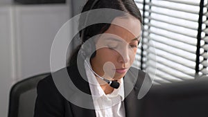 Competent female operator working on computer and while talking with clients.