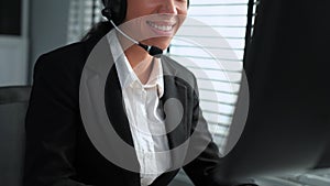 Competent female operator working on computer and while talking with clients.