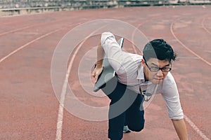Competition business concept. Confident young Asian businessman with laptop ready run to forward on race track