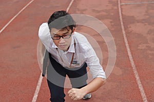 Competition business concept. Confident young Asian businessman with laptop ready run to forward on race track