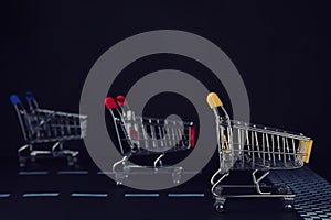 Competition concept. Shopping carts racing towards finish line