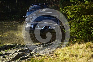 Competition, energy and motorsport concept. Auto racing on fall nature background. Off road vehicles or SUV overcomes